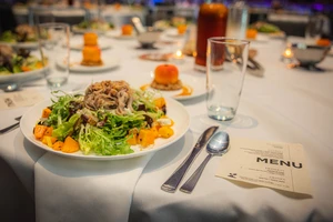 A dining table set with a fresh salad.