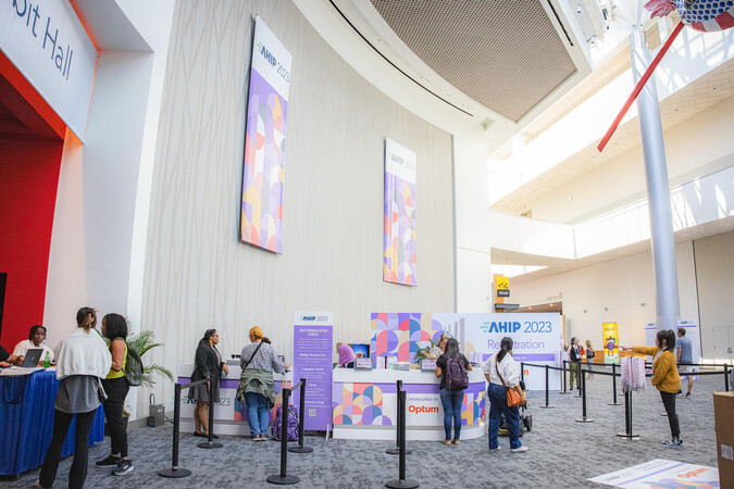People gather at a brightly decorated lobby.
