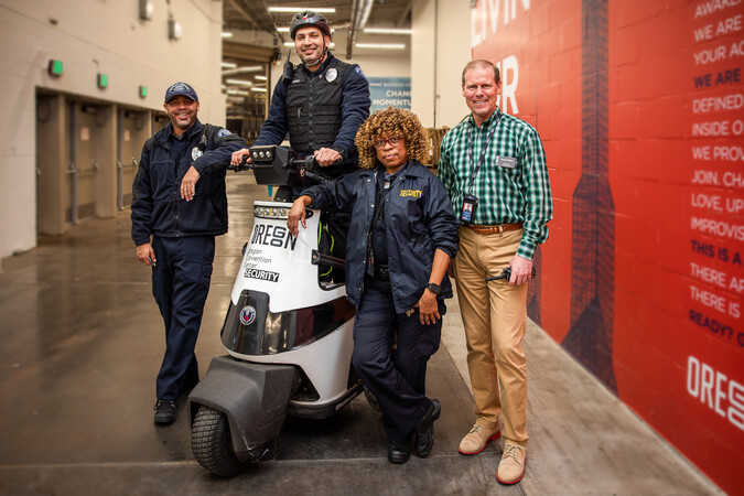 Four public safety staff stand confidently in a hallway.