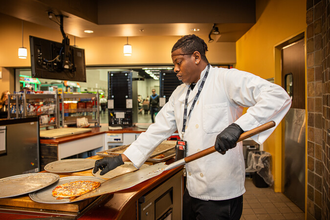 Pizza being made in a kitchen.