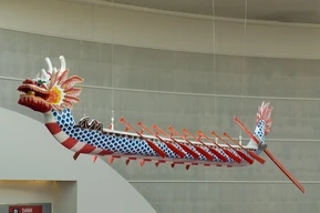 A 41-foot Chinese dragon boat suspended in a large building lobby.