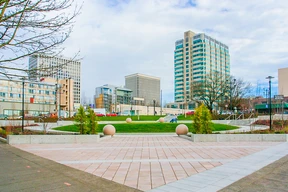 A grassy plaza with decorative stone spheres.