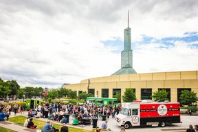 Crowd gathers near vibrant food trucks.