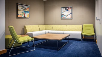 Seating area with a green and white L-shaped sofa.