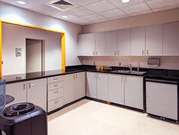 A modern breakroom with grey cabinets.